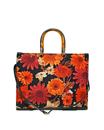 floral tote bag with red and orange flowers on a black background, featuring a tortoise top handle and black shoulder strap.